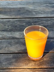 orange juice in a glass on wooden table.