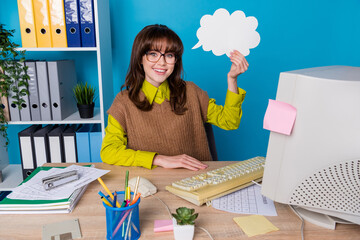 Photo of pretty cute lady wear brown vest spectacles sitting office working obsolete gadget cloud empty space isolated blue color background