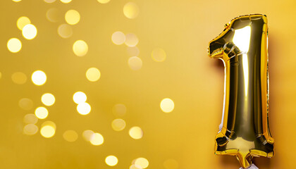 Banner with number 1 golden balloons with copy space. One years anniversary celebration concept on a yellow background with shiny bokeh.
