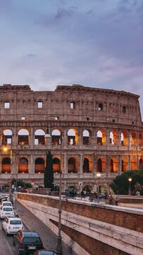 Rome, Italy. Colorful Sunset Sky Above Colosseum Also Known As Flavian Amphitheatre In Evening Time. Vertical Footage Video City Hyperlapse. Night Traffic Light Trails Near Famous World Landmark.