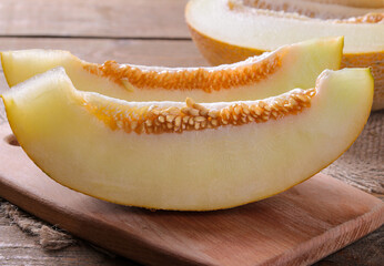 Delicious, healthy, fresh melon slices on a black table.