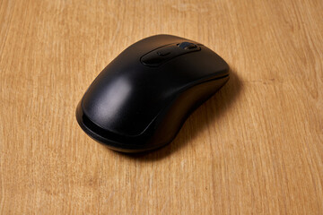 Black bluetooth mouse on a table.