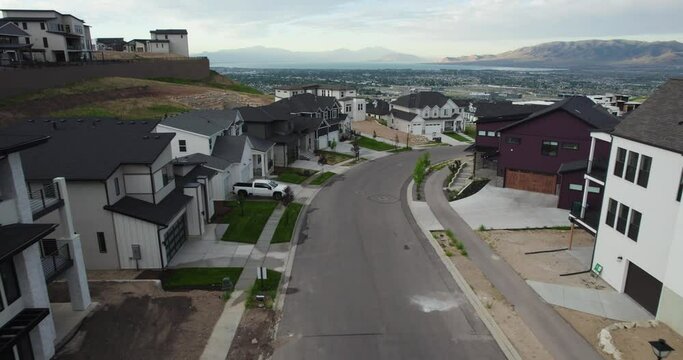 Aerial reverse dolly above white black new build modern homes, lehi utah