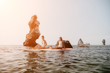 Woman sup yoga. Happy sporty woman practising yoga pilates on paddle sup surfboard. Female...