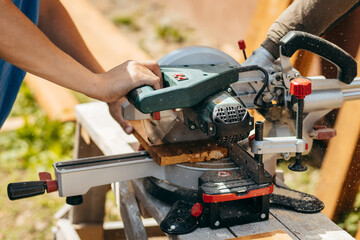 Adult man assembling a modern  wooden fence