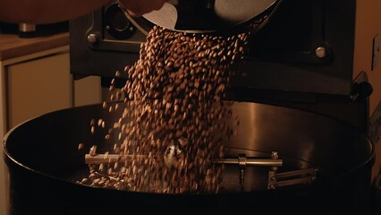 Production of fresh fried coffee beans. Roast master opens roasting coffee machine. Roasted coffee beans fall down on a cooling plate of an oven