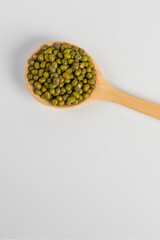 Mung beans isolated on spoon wooden on white background