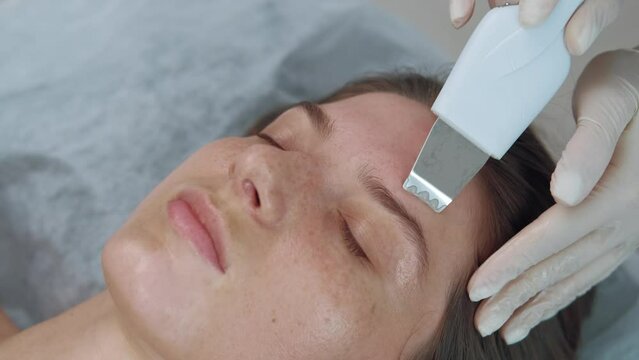 Video of cosmetician using ultrasonic device for cleaning face in a beauty salon.