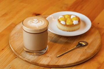 Cappuccino with lemon tart on wooden table