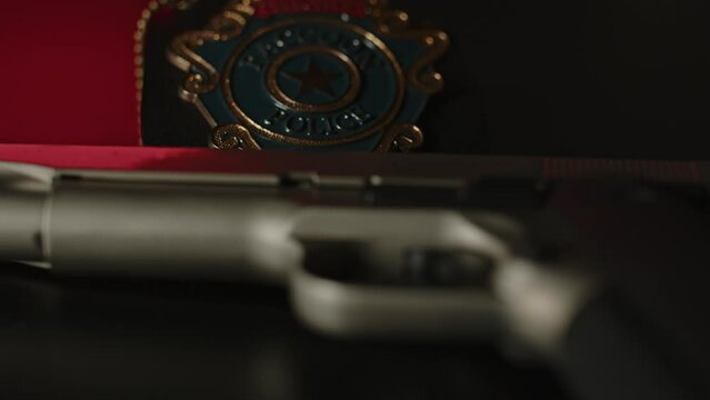Dolly out of a police badge lying behind a pistol