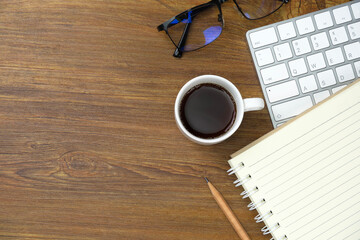 Top view above of office desk table with keyboard computer and coffee. Business and finance concept. Workplace. Flat lay with blank copy space. Stone texture.