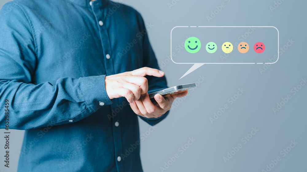Aufkleber Client hands using a mobile phone with pop up smile face icon for feedback review satisfaction service opinion and testimonial. Customer service experience assessment and business satisfaction survey.