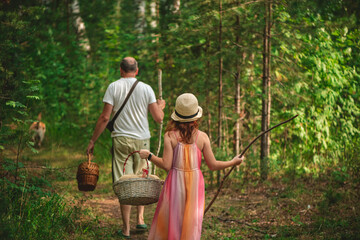 A girl and her father go with baskets through a holiday village to the forest for mushrooms