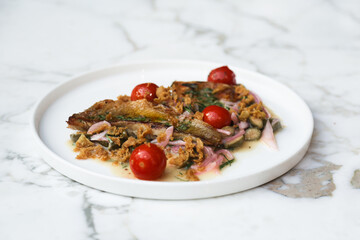 Roasted fish with tomatoes and onion