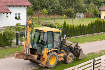 Obraz na płótnie Canvas Yellow tractor. Mini excavator bulldozer. Earthmoving company in the rural area.