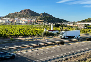 Semi truck with Semi-trailer driving along highway. Truck Goods Delivery by roads. Services and...