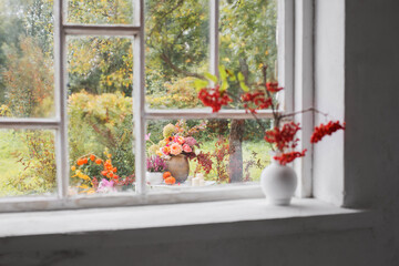 rowan berries in white vase on old white windowsill