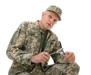 Portrait of Ukraine army soldier sits with a spoon and fork in his hands and demands some food,...