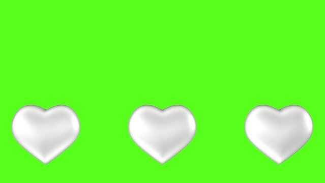 Emerging big silver hearts against a green screen.  Video effect for valentine's day and wedding.  3D animation.