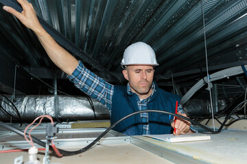 contractor in roof space making notes