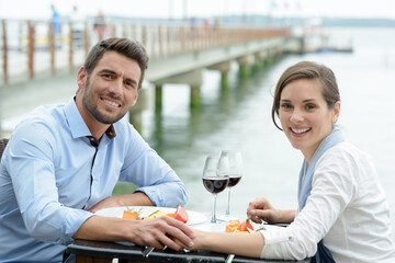couple holding hands while having meal on terrace