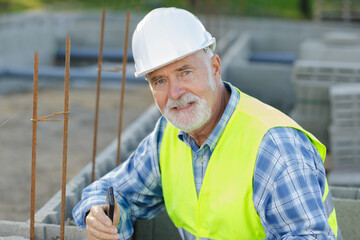 portrait of skilled professional bricklayer wearing helmet