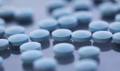 Tablets scattered blue color on the table of pharmaceutical laboratory pill for the prescription and treatment various diseases chemistry