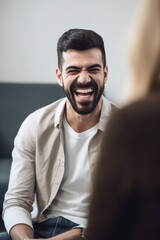 shot of a young man laughing in the waiting room of his psychiatrist - obrazy, fototapety, plakaty