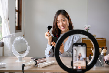 Woman live streaming while applying makeup.