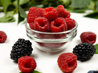 Small bowls with raspberries  on a white table, background 