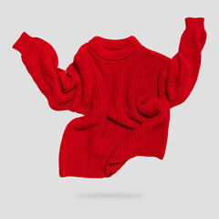 Red flying knitted sweater isolated on gray background. Women's cotton wool sweater, cardigan, pullover, jacket. Clothes levitation concept, cut out object for design. Mockup