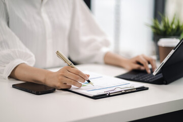 Women work on laptop on the table at the office with information documents.