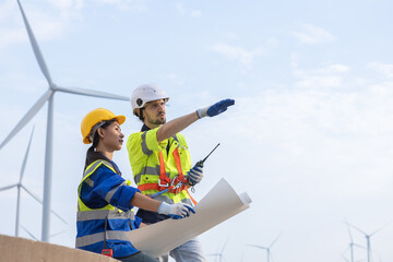 Wind turbine technician checking and maintenance at turbine station. Man and woman engineer working...