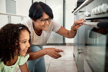 Baking, oven and a senior woman with her grandchild in the kitchen of a home together for cooking....