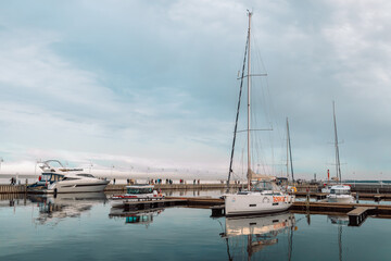 Fototapeta na wymiar Yacht parking in harbor, harbor yacht club in Marina. Beautiful Yachts in blue sky background
