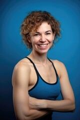 Fototapeta na wymiar fitness, woman and portrait smile in gym for wellness, cardio or goals with blue background