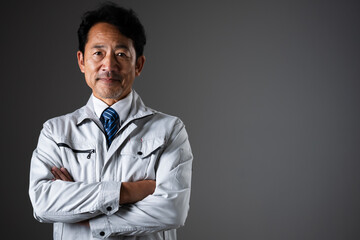 腕を組むミドル男性　作業服イメージ