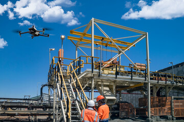 drone operator with remote control for a thermal UAV camera, surveying a construction site, in an...