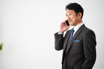 スマートフォンで通話するミドル男性　ビジネスイメージ