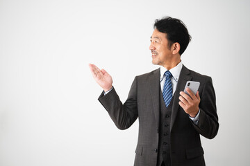 スマートフォンを持って案内をするミドル男性　ビジネスイメージ