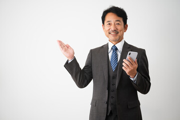スマートフォンを持って案内をするミドル男性　ビジネスイメージ