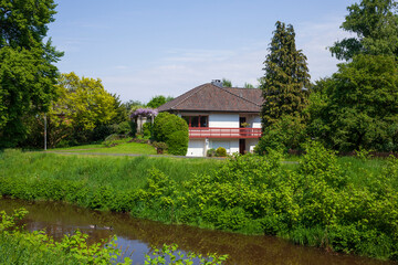 Modernes Wohnhaus am Fluss Wörpe im Frühling, Lilienthal, Niedersachsen, Deutschland