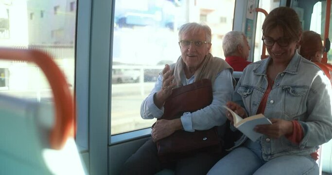 Senior man traveling with caretaker inside tram - Transportation concept