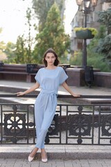 Portrait of an Armenian brunette girl in elegant blue clothes on a sunny summer day.