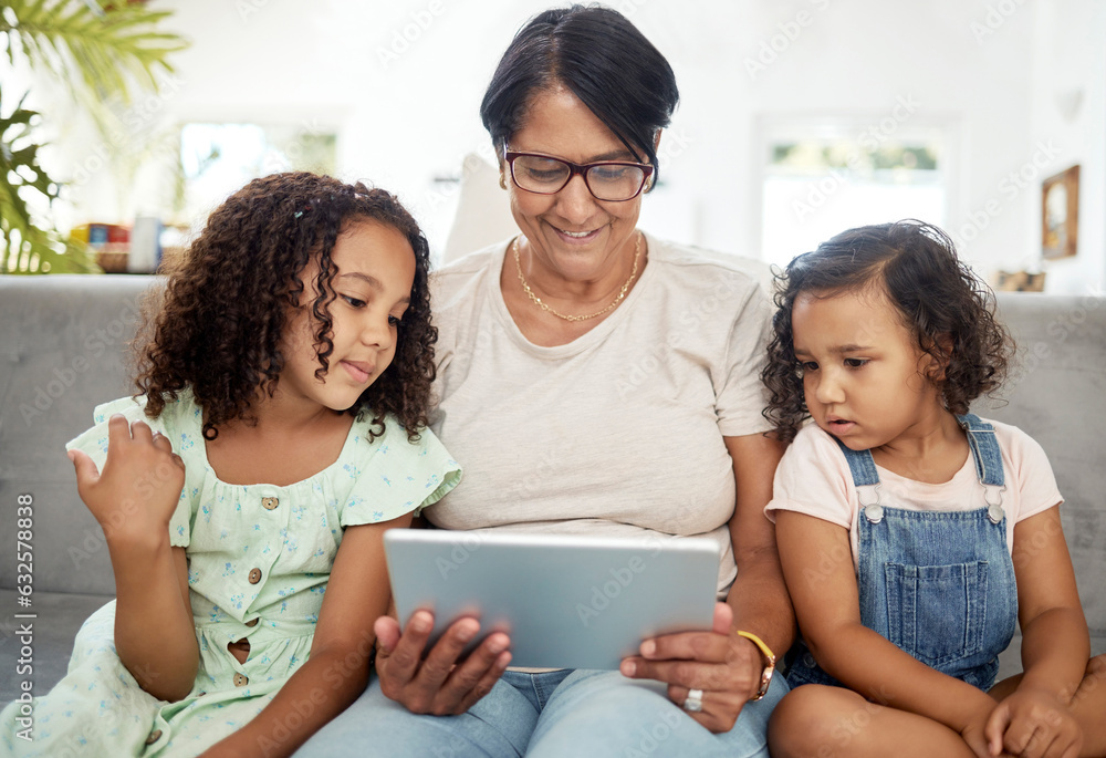 Sticker Tablet, bonding and grandmother watching with children enjoying a video or movie together in the living room. Happy, smile and kids streaming a show on digital technology with a senior woman at home.