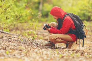 Biologist or botanist recording information, photography about tropical plants in forest. The concept of hiking to study and research botanical gardens by searching for information.