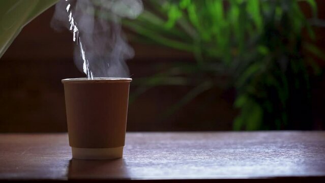 Pour boiling water from the kettle into a paper cup
