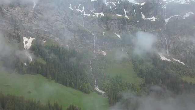 Snow patches and waterfalls, Bi de Sibe Bruenne, sources of the Simme, drone shot, Lenk, Bern, Switzerland, Europe