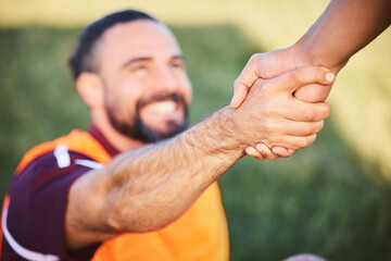 Hands, rugby and teamwork with a man helping a friend while training together on a stadium field...
