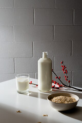 Glass and bottle of milk with jar of oatmeal in the morning light